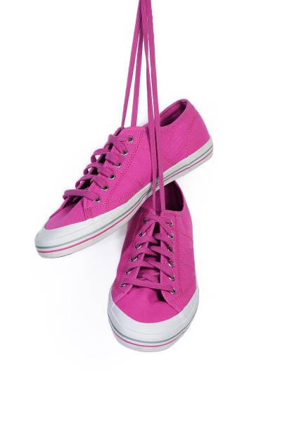 istock Magenta sneakers hang on laces isolated on a white 1128618187