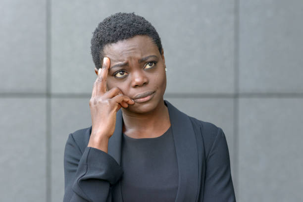 istock Pensive woman with her fingers on her temple 1128621673