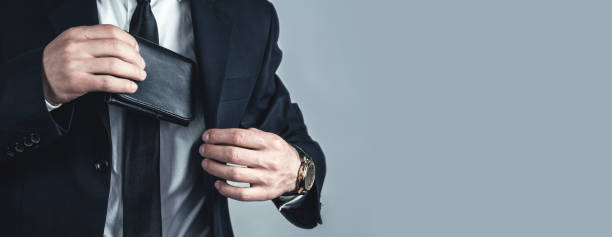 istock Businessman pulls his leather wallet into suit pocket. 1128623760