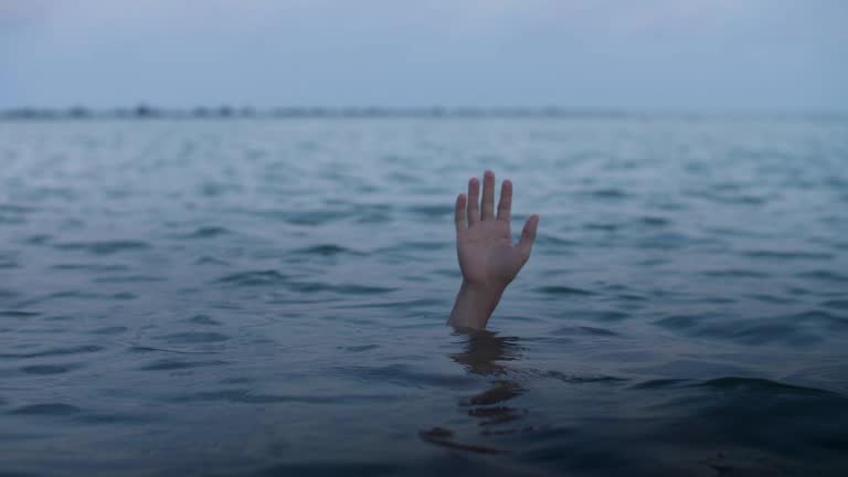 Hand of a drowning man sinks into the water,concept of a person mired in debt and unable to help himself