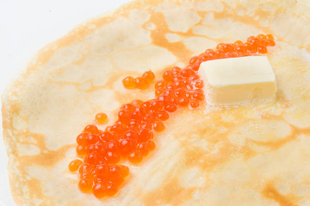 Pancakes with caviar and oil on white background.