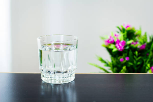 istock Glass of water on the table background 1128625041