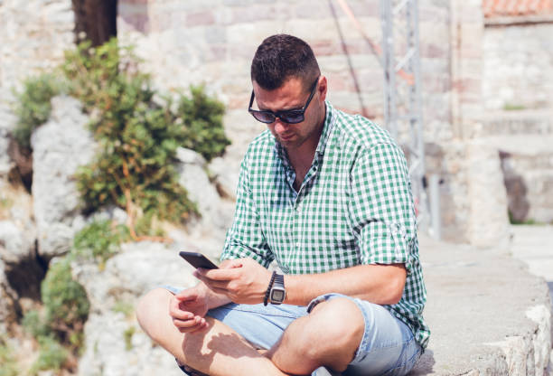 istock Man using cellphone outdoor in Budva Montenegro old town. 1128626714