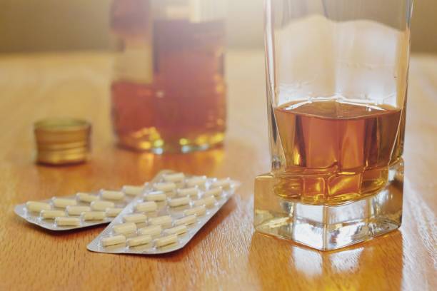 pills and alcohol on the table, dependency concept - alcohol drug abuse alcoholism pill imagens e fotografias de stock