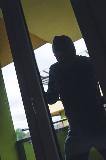 istock Burglar Breaking Into House 1128628086