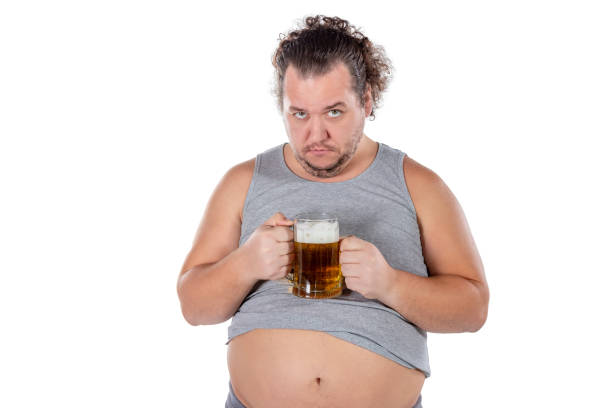 istock Funny fat man feeling happy and relaxed, holding fresh cold beer in his hands on white background 1128629816