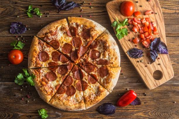 istock Pizza with cheese, pepperoni, chicken and pepper, a slice for a gourmet dinner 1128630546