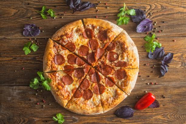 istock Pizza with cheese, pepperoni, chicken and pepper, a slice for a gourmet dinner 1128630560