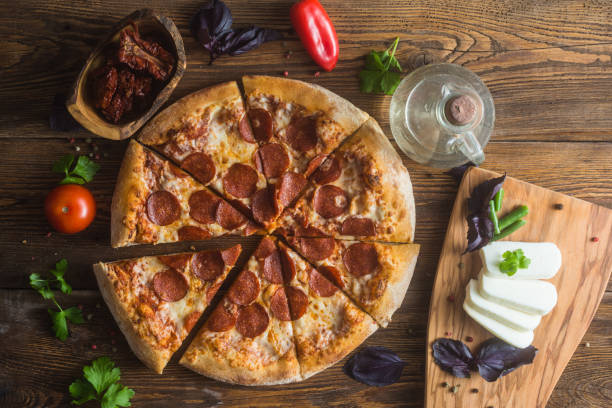istock Pizza with cheese, pepperoni, chicken and pepper, a slice for a gourmet dinner 1128630604
