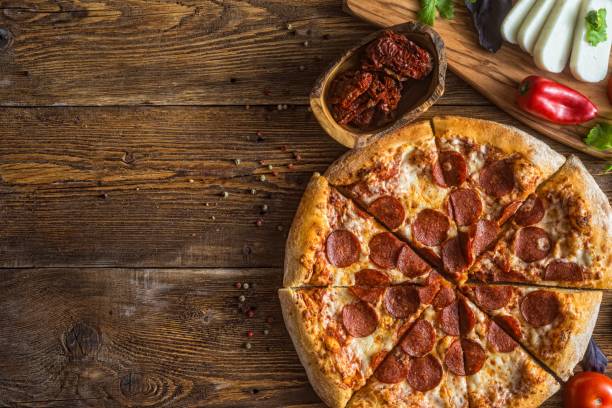 istock Pizza with cheese, pepperoni, chicken and pepper, a slice for a gourmet dinner 1128630683
