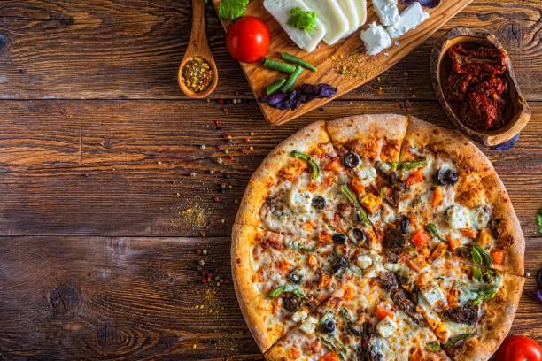 istock Pizza with cheese, pepperoni, chicken and pepper, a slice for a gourmet dinner 1128630719