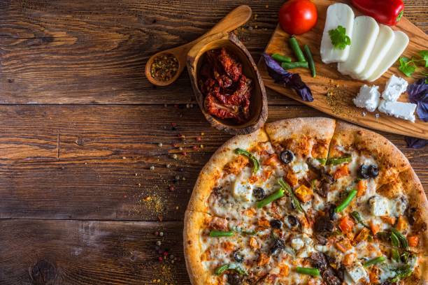 istock Pizza with cheese, pepperoni, chicken and pepper, a slice for a gourmet dinner 1128630730