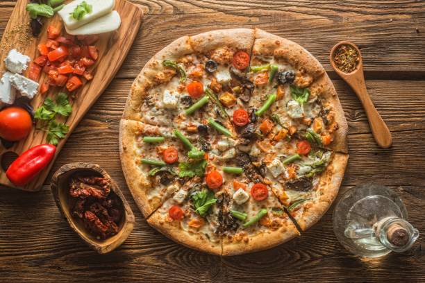 istock Pizza with cheese, pepperoni, chicken and pepper, a slice for a gourmet dinner 1128630751