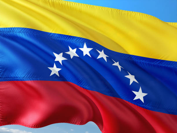 flag of venezuela waving in the wind against deep blue sky. high quality fabric. - venezuelan flag imagens e fotografias de stock