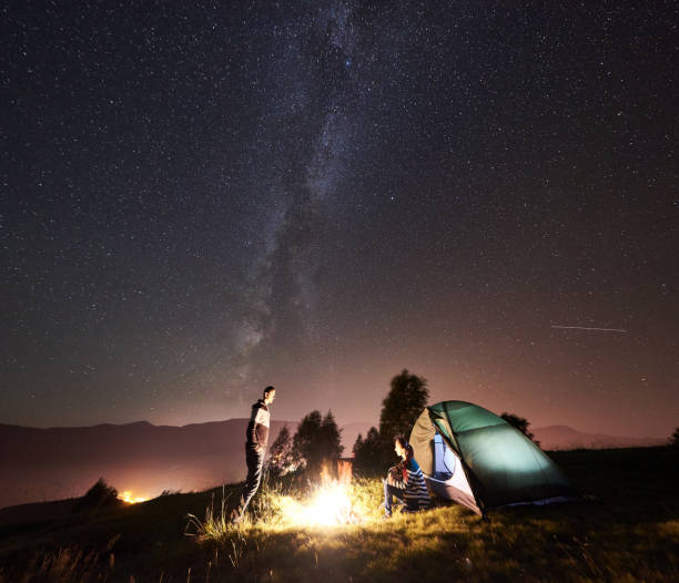 istock Couple tourists resting at night camping under stars 1128633176
