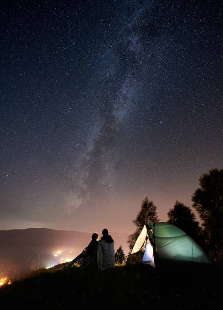 星空の下で夜のキャンプで休んでカップル観光客 - camping family nature tent ストックフォトと画像