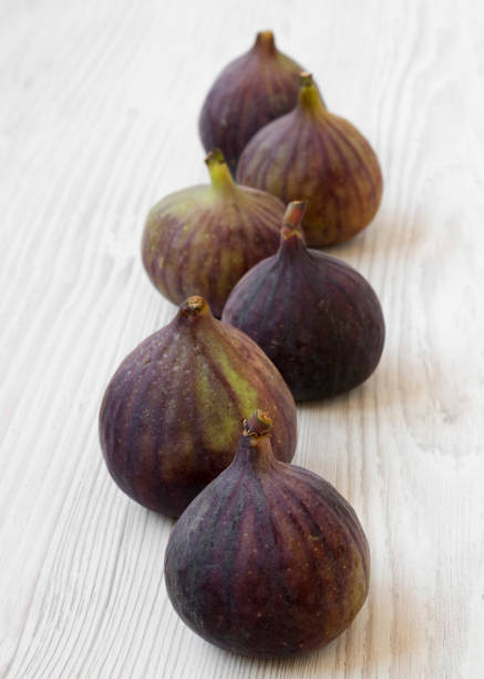 istock Fresh figs on a white wooden background, low angle view. 1128634568