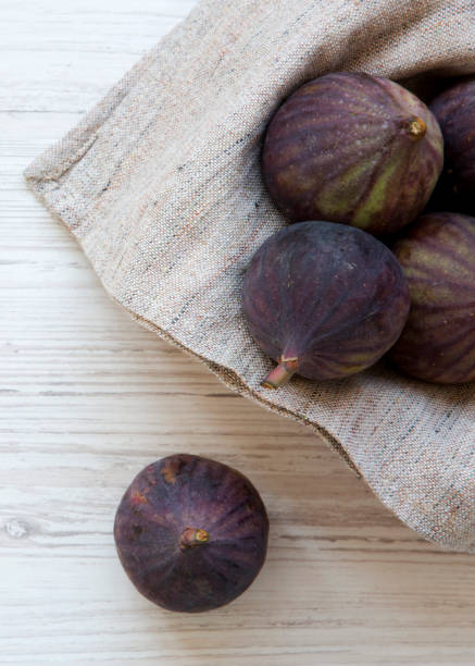 istock Fresh figs in a bowl on a white wooden surface, top view. Overhead, from above. 1128634570