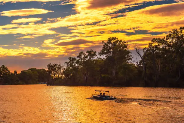 Sunset over Murray river with people riding a boat in Mildura, Australia
