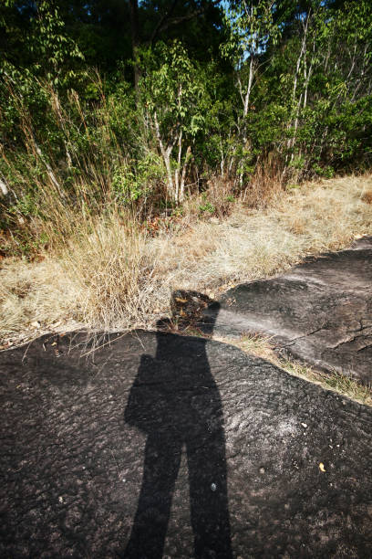 istock Woman self portrait with a Shadow on rock floor in forest 1128636801