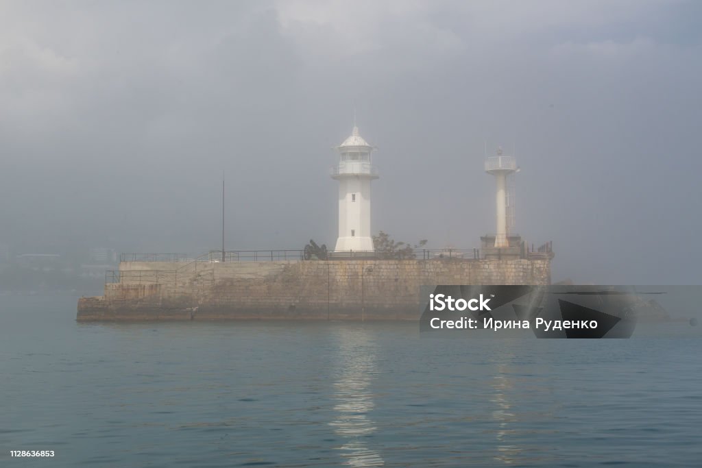 island lighthouse in the fog island lighthouse in the sea fog Architecture Stock Photo