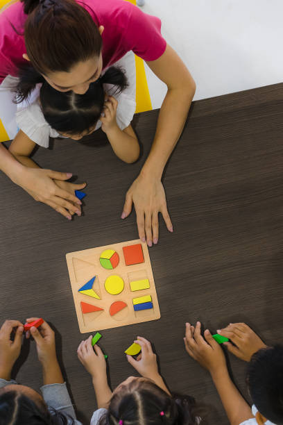 istock Asian teacher play geometry block with student. 1128637052