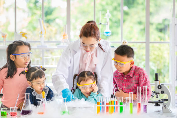 istock Teacher pour chemicals into glass bowl in lab. 1128637202