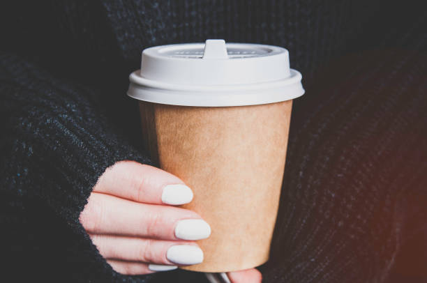 istock Woman holding a paper cup in her hands 1128638278
