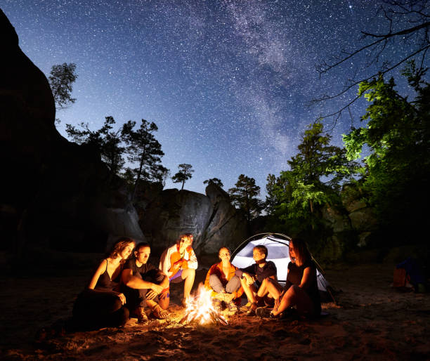 amici escursionisti appoggiati accanto a campo, falò, tenda di notte - friendship camping night campfire foto e immagini stock