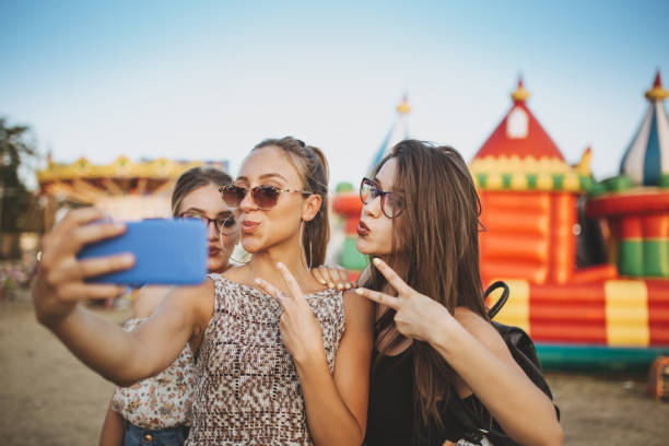 istock Girls taking selfies by inflatable castle 1128638851