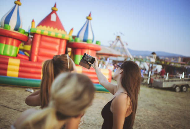 istock Girls taking selfies by inflatable castle 1128639525