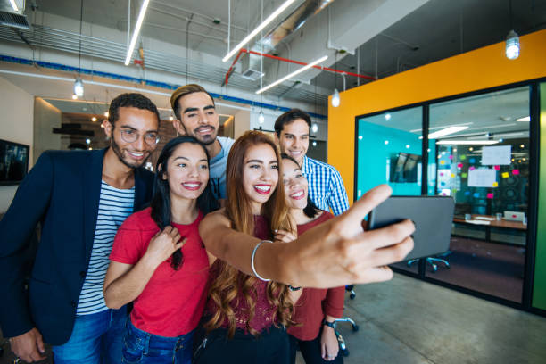 istock Colleagues taking selfie after project conference in company with Hispanic employees 1128642155