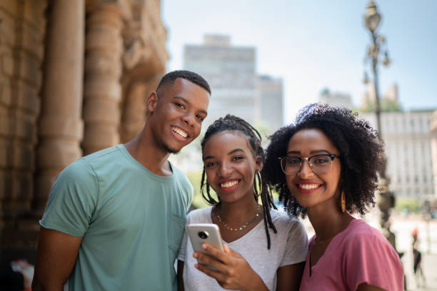 istock Young latinx group using smartphone in the city 1128642694