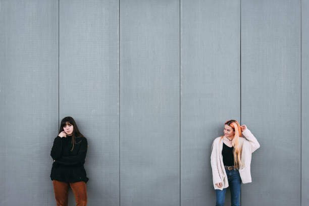 istock two girls hipster millennial against a wall with space for text 1128647381
