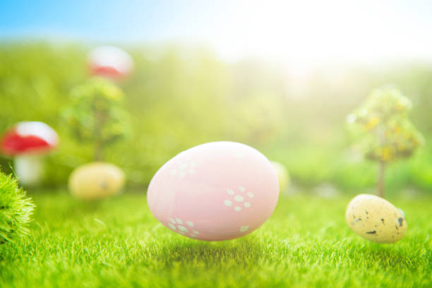 istock Easter background with pink Easter eggs on green grass in pastel colors in spring of Dreamland or fairy world 1128647712