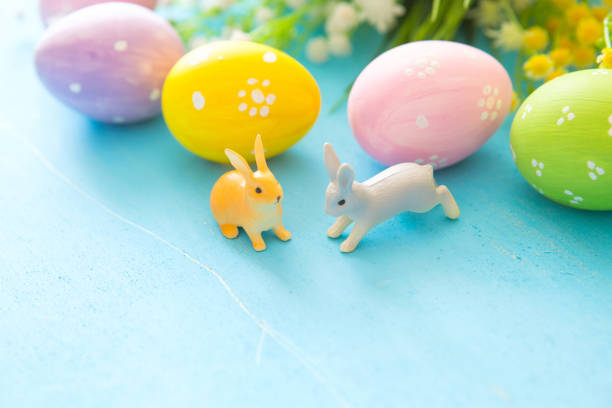 istock Colorful painted Easter eggs with flowers on blue wooden background 1128647835