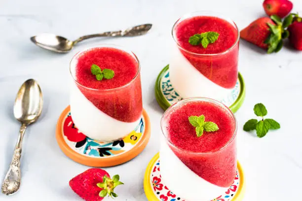 Strawberry Panna Cotta with Mint Leaves Topping in the Glasses. Popular Italian Dessert of Cooked Cream.