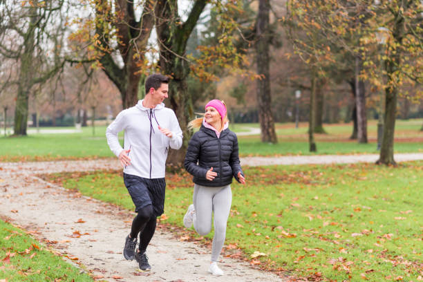 istock Young couple jogging in autumn nature 1128654559