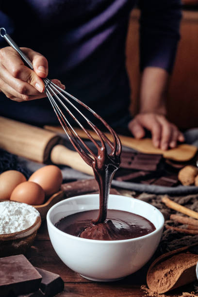 Young woman hands making chocolate mousse on a wooden table in a rustic kitchen Young woman hands making chocolate mousse on a wooden table in a rustic kitchen molten stock pictures, royalty-free photos & images