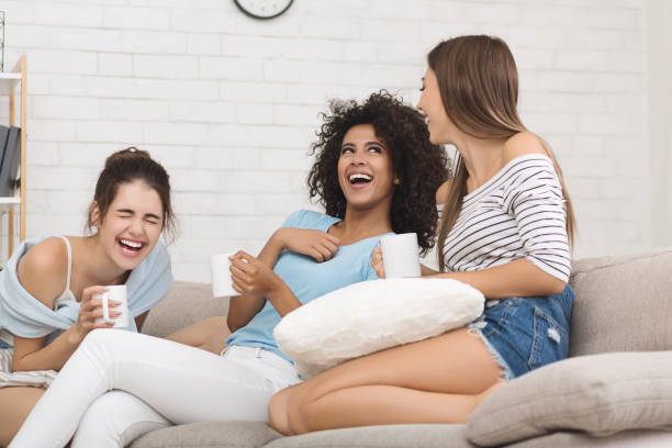 istock Girlfriends laughing with jokes, drinking coffee at home 1128657629
