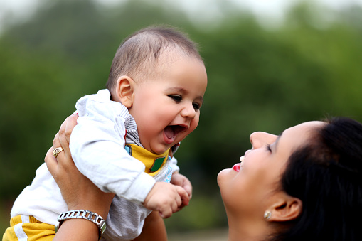 Mother & child of Indian ethnicity playing together outdoor in the nature.