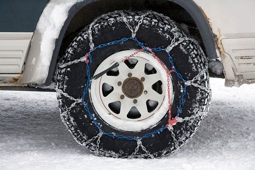 Snow chains on the wheel of a 4X4 vehicle in Greenland.