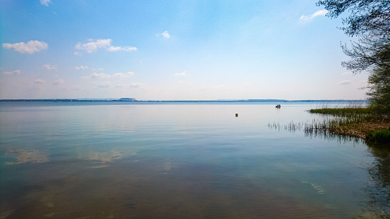 An empty big flat lake with the blue sky above