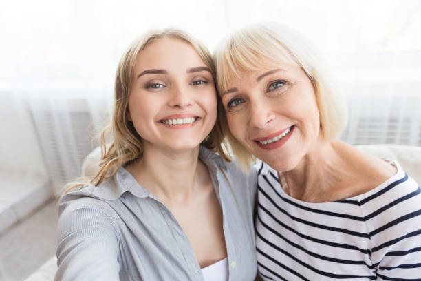 Senior mother and daughter taking selfie at home