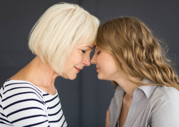 istock Senior mom and her daughter touching with foreheads 1128663775