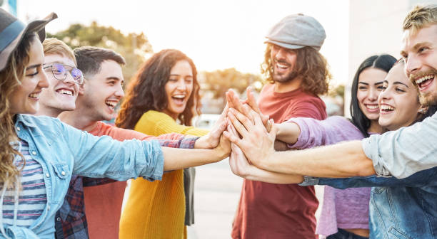 istock Young friends stacking hands outdoor - Happy millennial people having fun joining and celebrating together - Friendship, empowering, teamwork, partnership and youth lifestyle concept 1128664372
