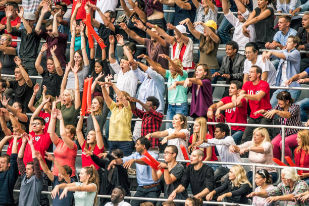 istock Crowd cheering for their team with arms raised 1128664600