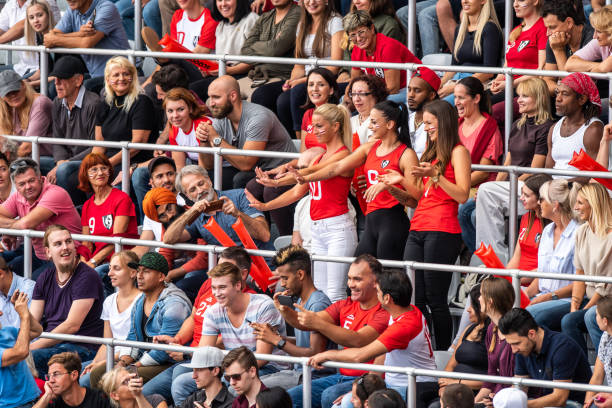 istock Three beautiful women in red cheering in a stadium crowd 1128664606