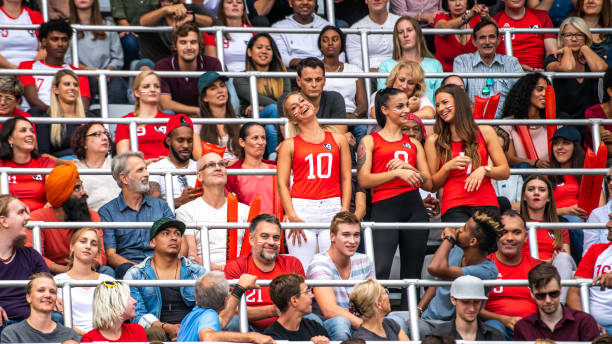 istock Three beautiful women in red cheering in a stadium crowd 1128664610