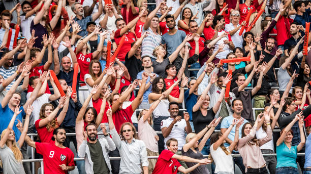 istock Crowds cheering for their team with arms raised 1128664615